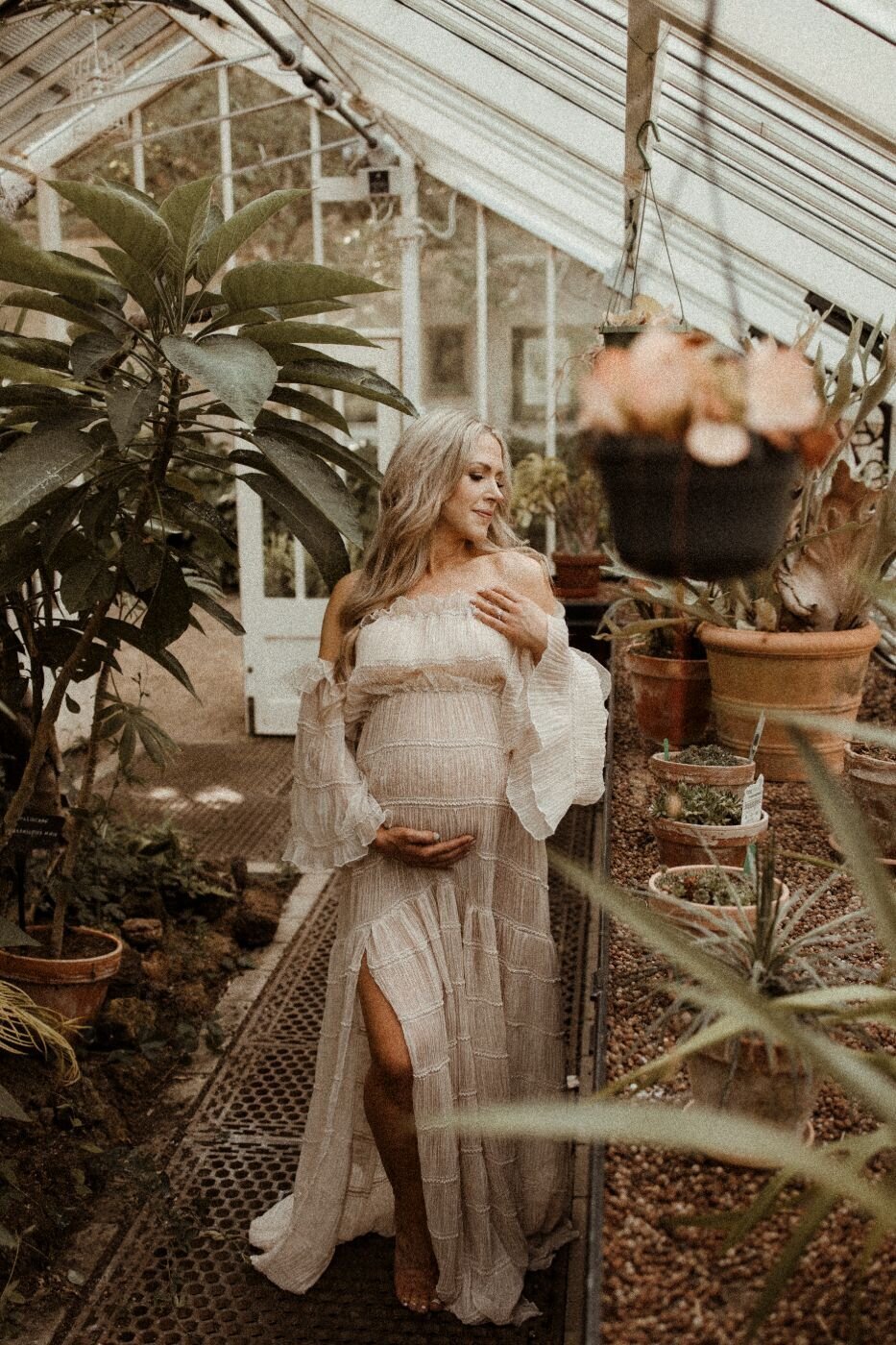 Mullingar maternity photographer: pregnant woman in greenhouse with plants.