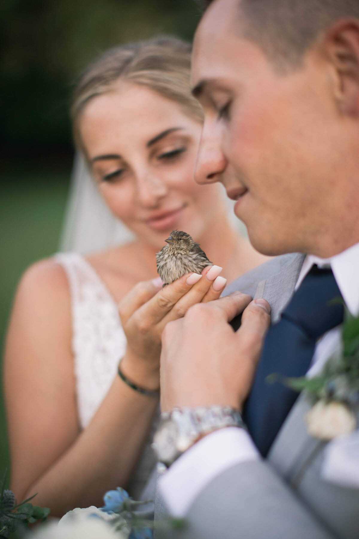 bride and groom holding bird