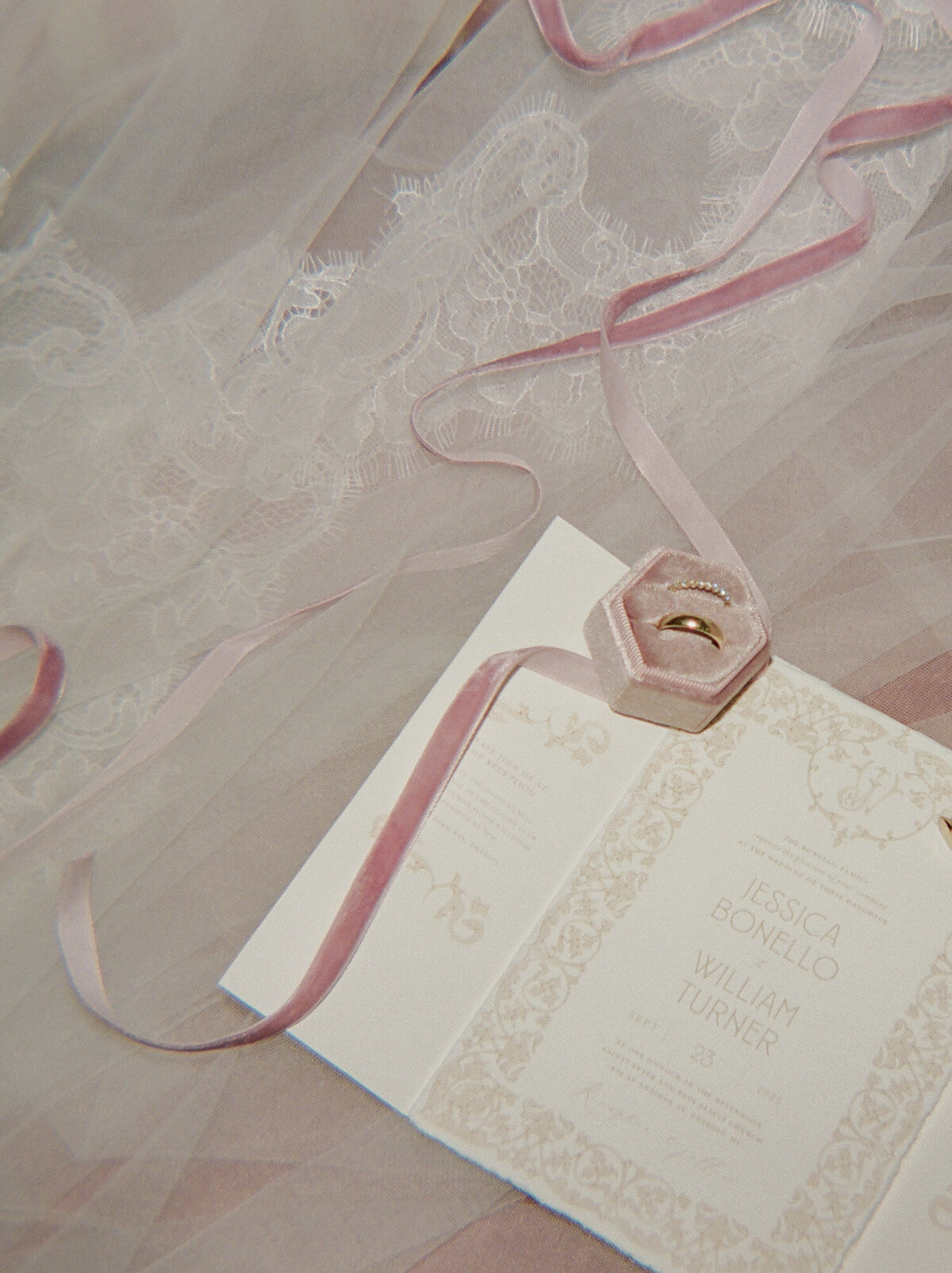 film wedding getting ready photo of a velvet ring box, ribbon, and invitation