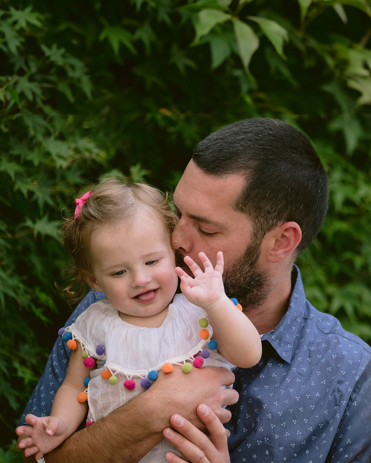 Dad snuggling his baby during a first birthday celebration in Novato, photographed by a San Francisco Bay Area birthday photographer.