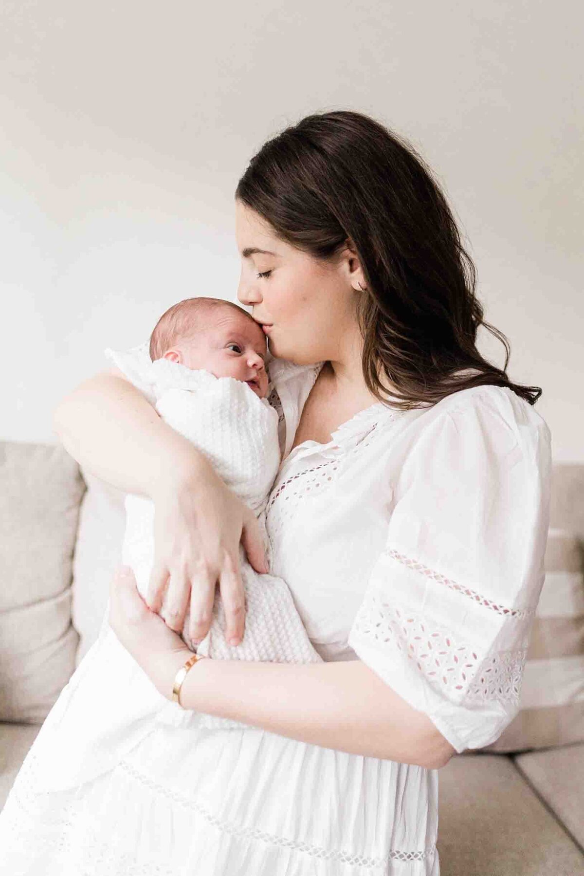 Mom kissing newborn son