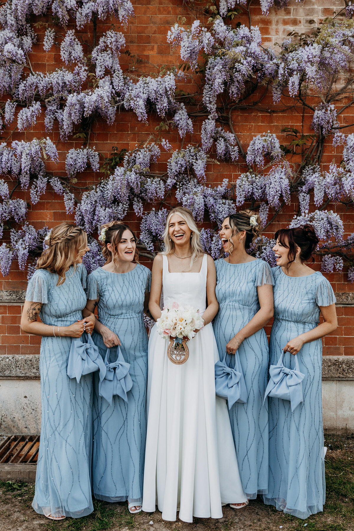 Bride and bridesmaids in front of wisteria at Thicket Priory York