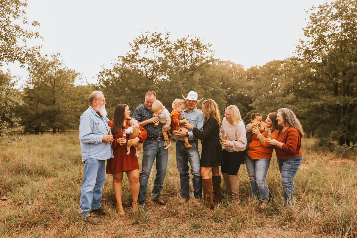 extended family in a field laughing with eachother