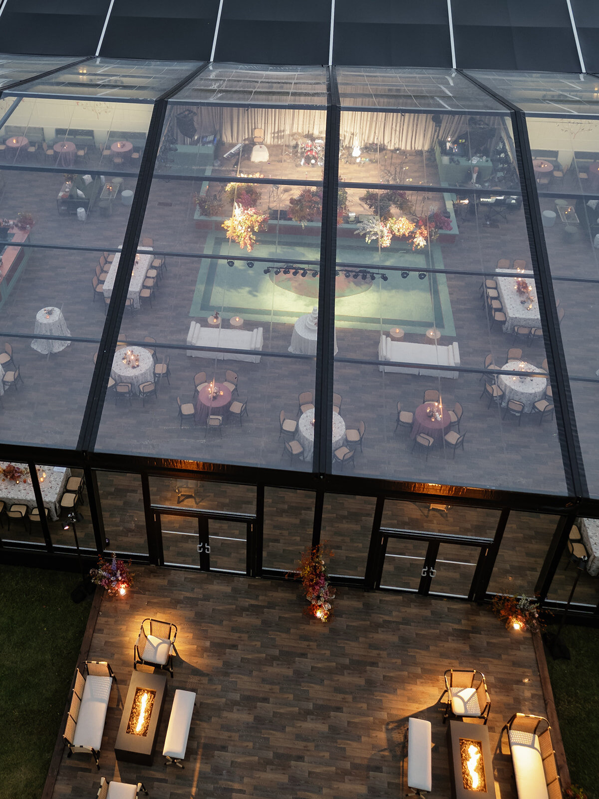 Interacting and sculptural floral clouds hang over the dance floor and bars of this fall wedding reception in Tennessee. Clear top tent build out for fall wedding reception in Tennessee hills.  Product clustered floral clouds in a tasteful fall color palette of copper, ruby, gold, burgundy, rust, and lavender. Orchids, bittersweet berries, butterfly ranunculus, and tulips are highlighted. Unique floral design with flower forward large scale installations. Design by Rosemary & Finch Floral Design in Nashville, TN.