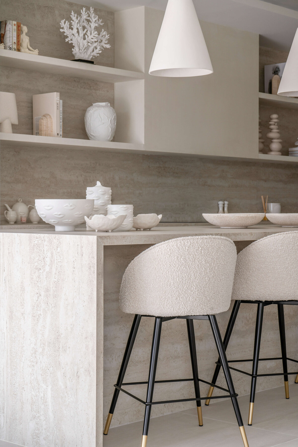 Cream textured barstools with black legs along chic kitchen bar.