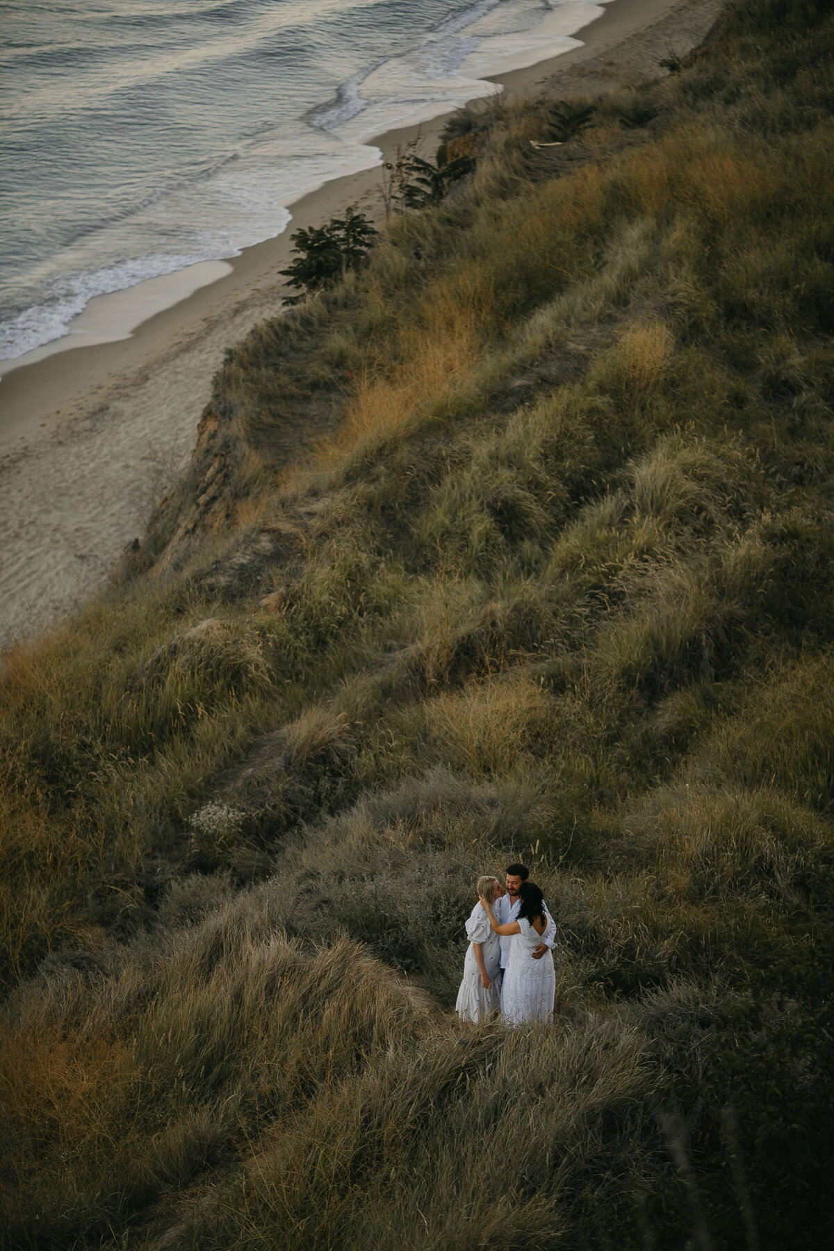 top-view-three-adult-people-hugging-grassy-hill-together