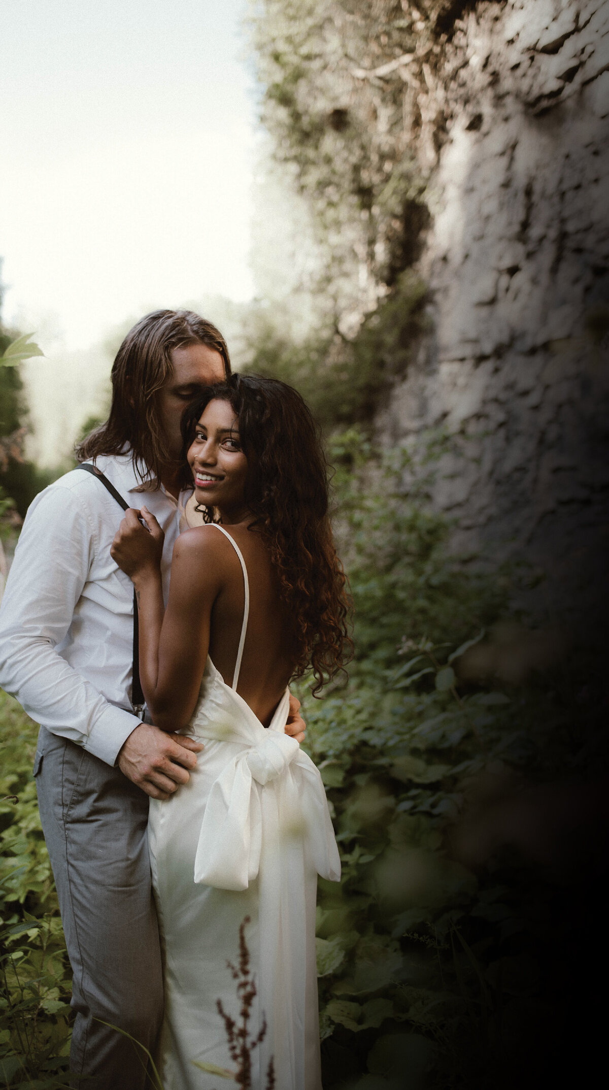 groom-kissing-bride-in-forest