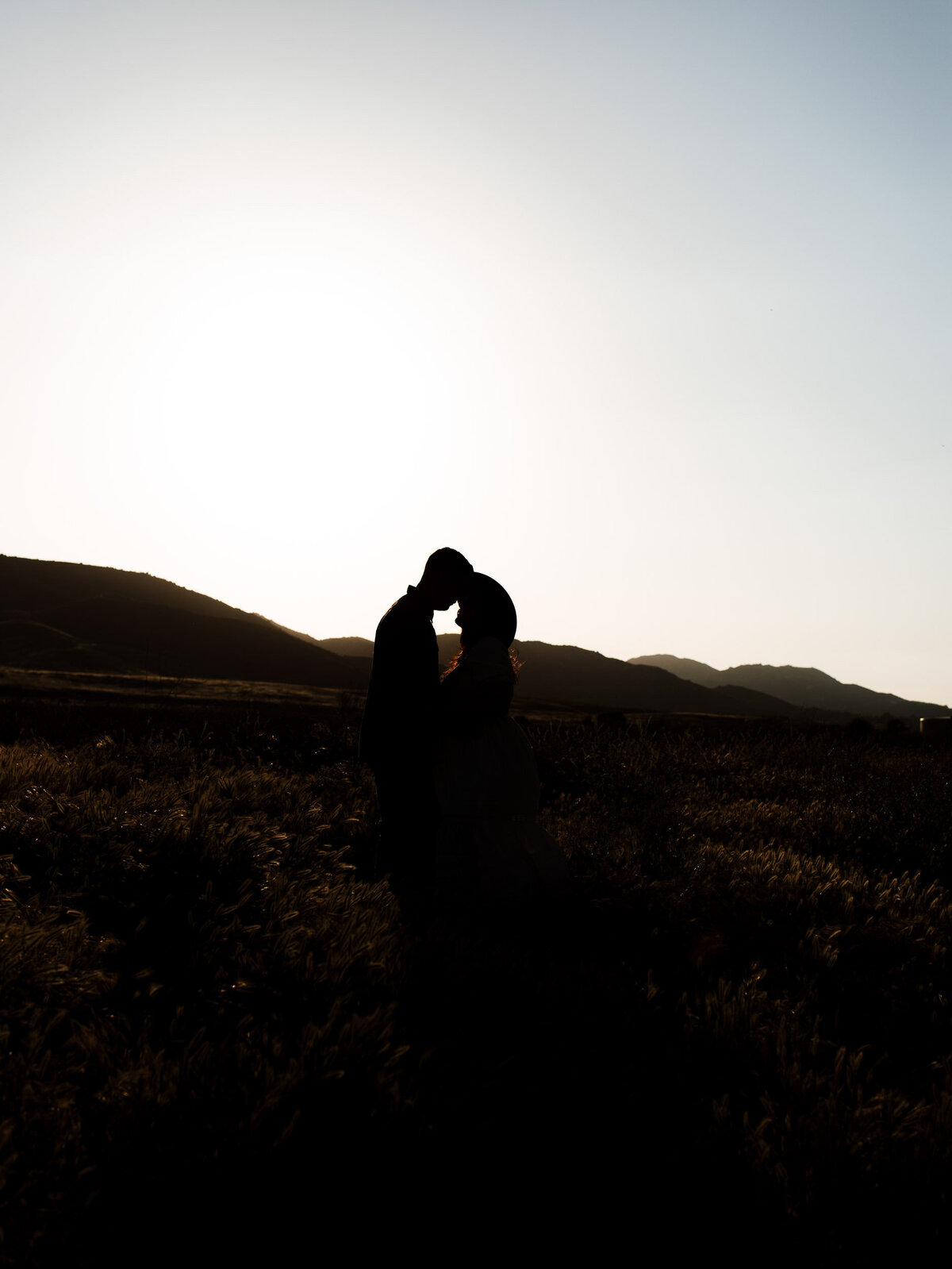 Maternity photo shoot in silhoutte at Murrieta mountains during sunset.