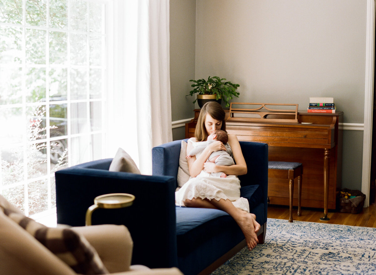 Mom snuggles her new son during a newborn session. Image by Raleigh newborn photographer A.J. Dunlap Photography.