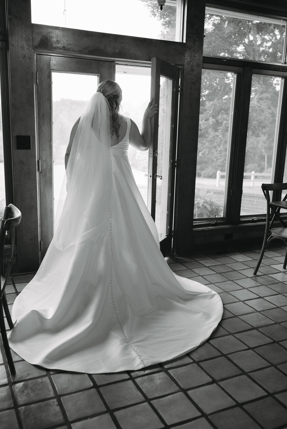 Bride looking out glass doors 