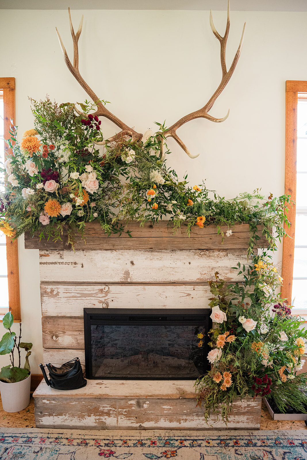 Wedding flowers on wooden fireplace mantel.