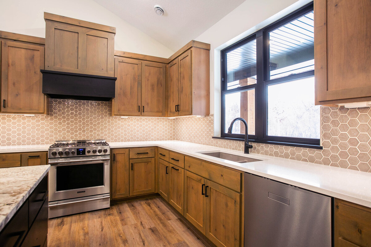 Open kitchen with dark cabinets, large island, and quartz countertops in an Elk River custom home