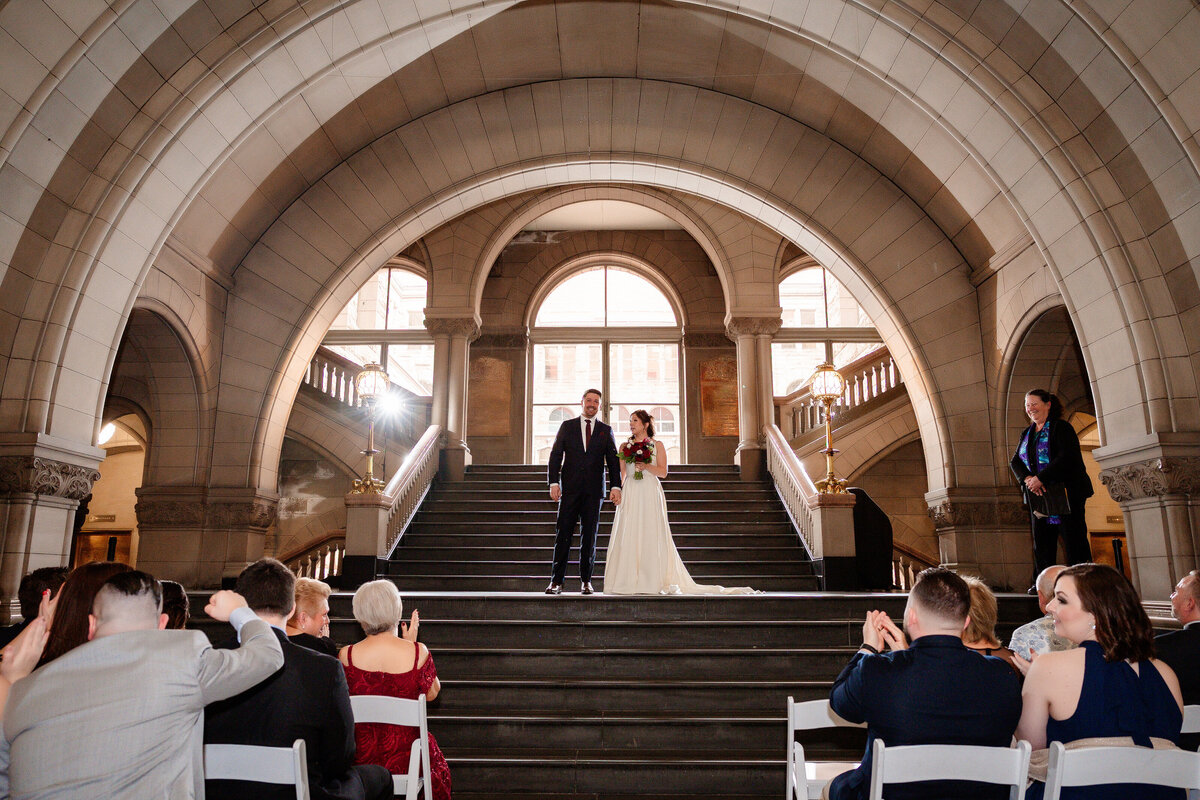 friends cheering and clapping for newly married couple at allegheny county courthouse
