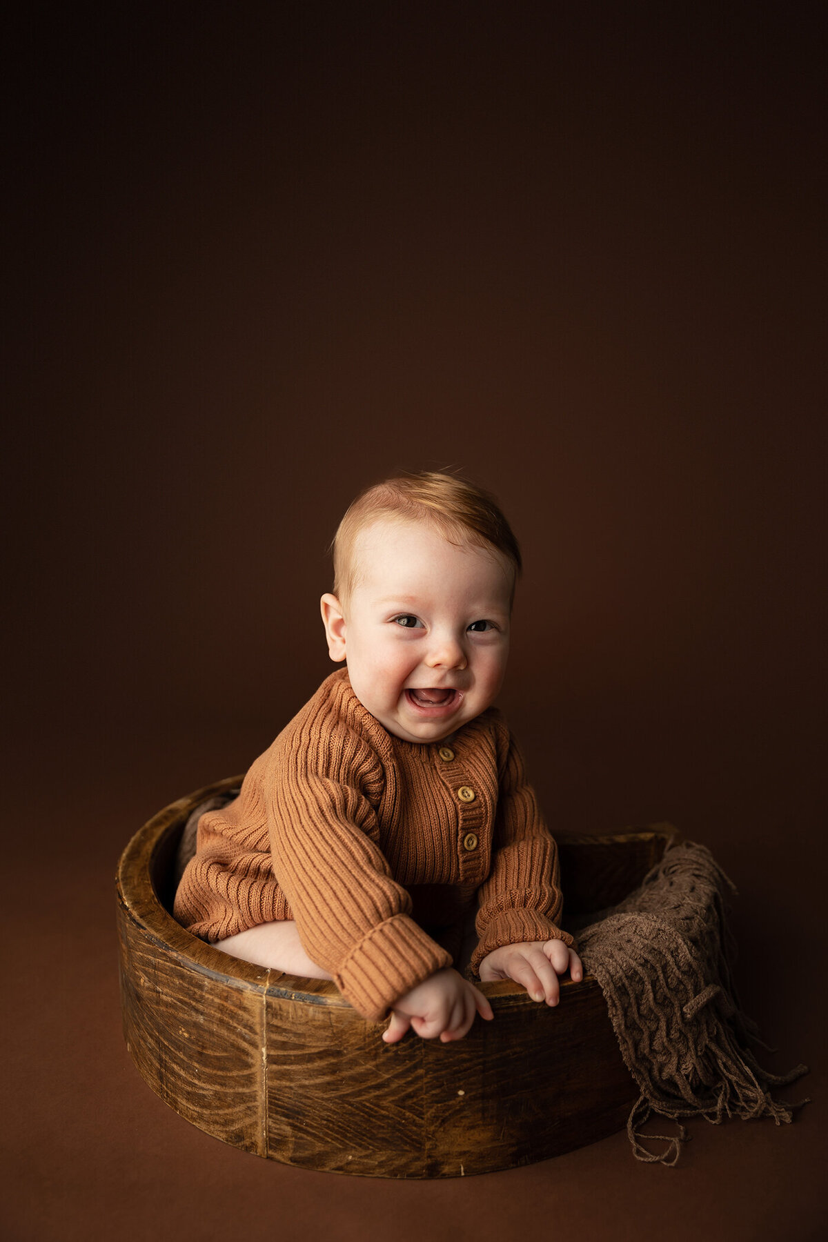 6 month old boy in sweater on brown backdrop for milestone studio session in phoenix arizona