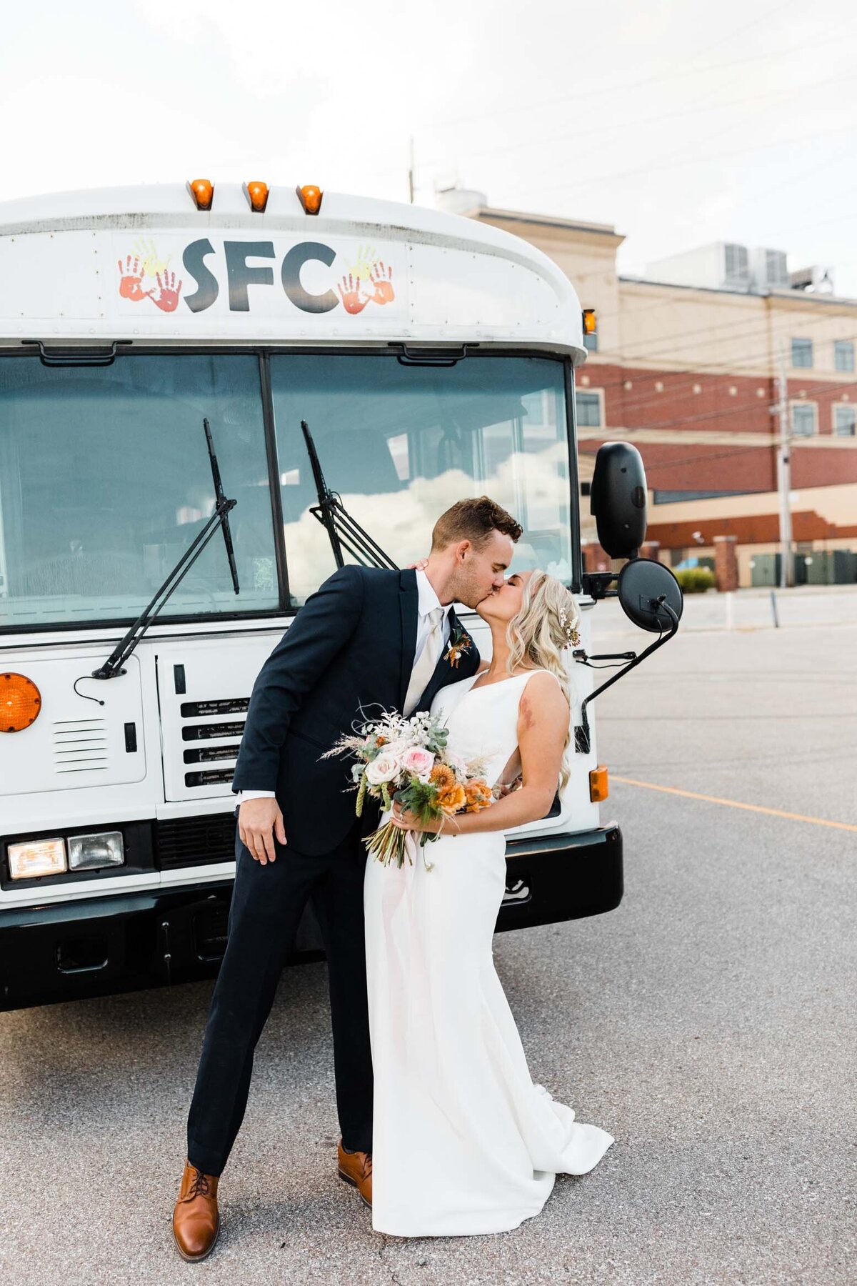 Bride and groom posing with a vintage vehicle during their wedding day in South Bend.