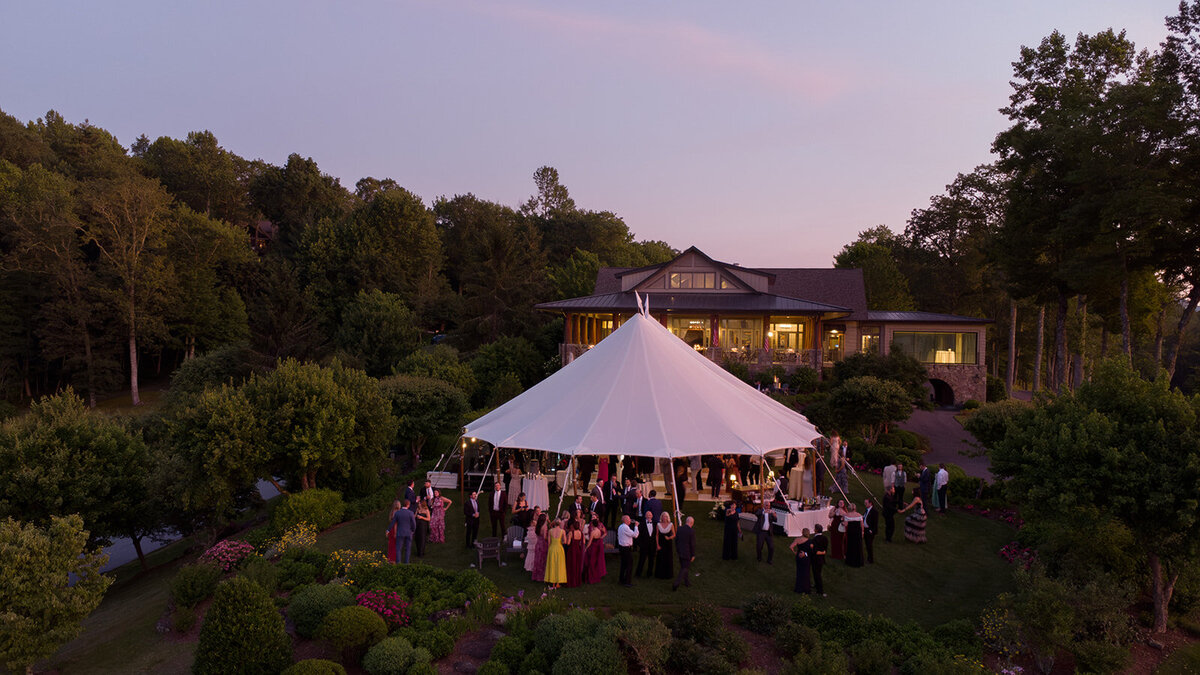 Drone photo of a tented wedding reception at sunset in the mountains of Highlands, North Carolina with sweeping Blue Ridge Mountain views.

