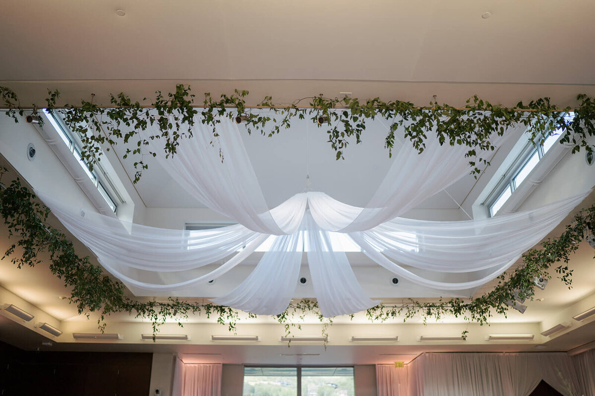 Elegant drapery and greenery adorns the ceiling of the Aspen Meadows Resort wedding reception venue.