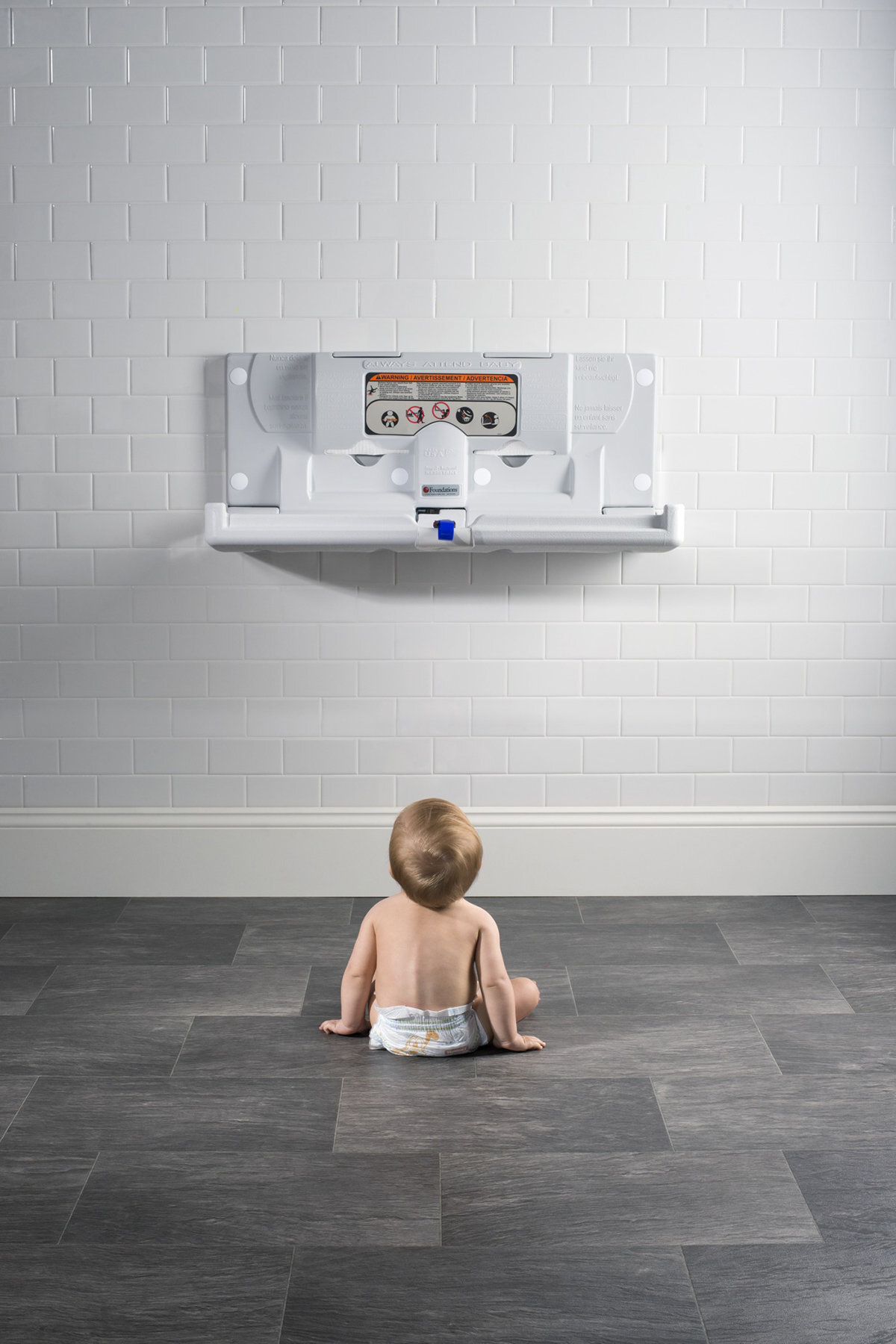 Advertising photograph of a baby with a washroom changing station