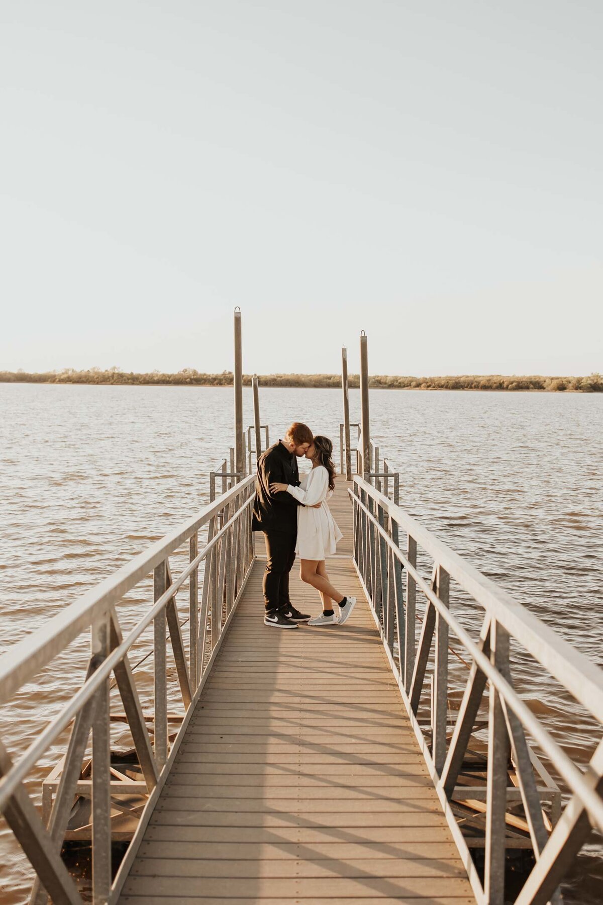 couple-embracing-on-dock-on-lake