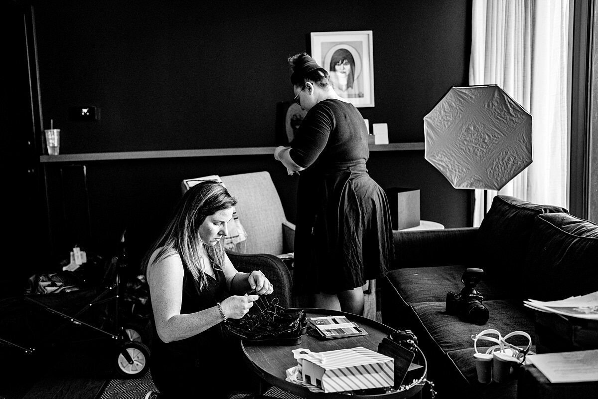 Black and White photo showing behind the scenes of a photographer on a wedding day