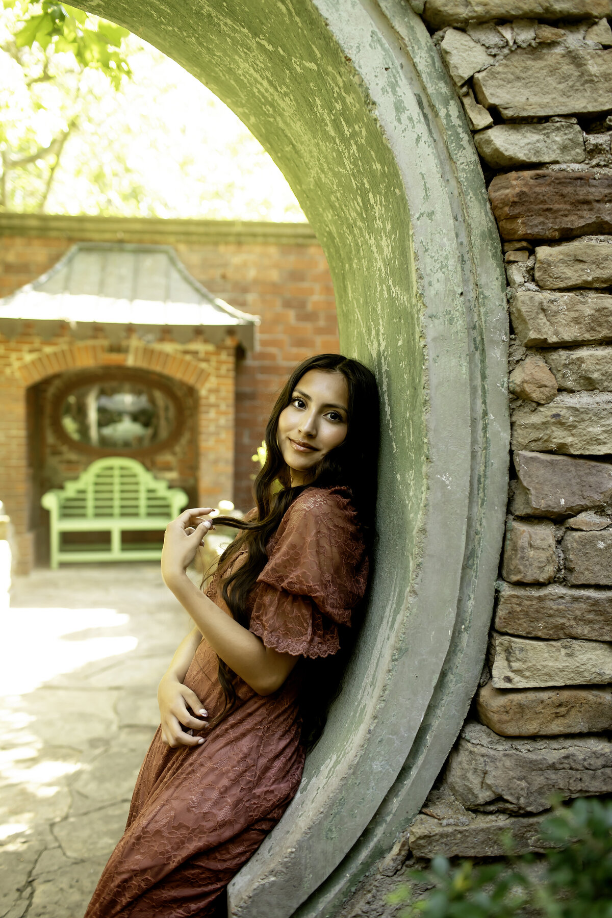 A senior photoshoot in the picturesque Chandor Gardens of Weatherford, TX, with the graduate standing amidst the flowers and greenery, symbolizing a new chapter ahead