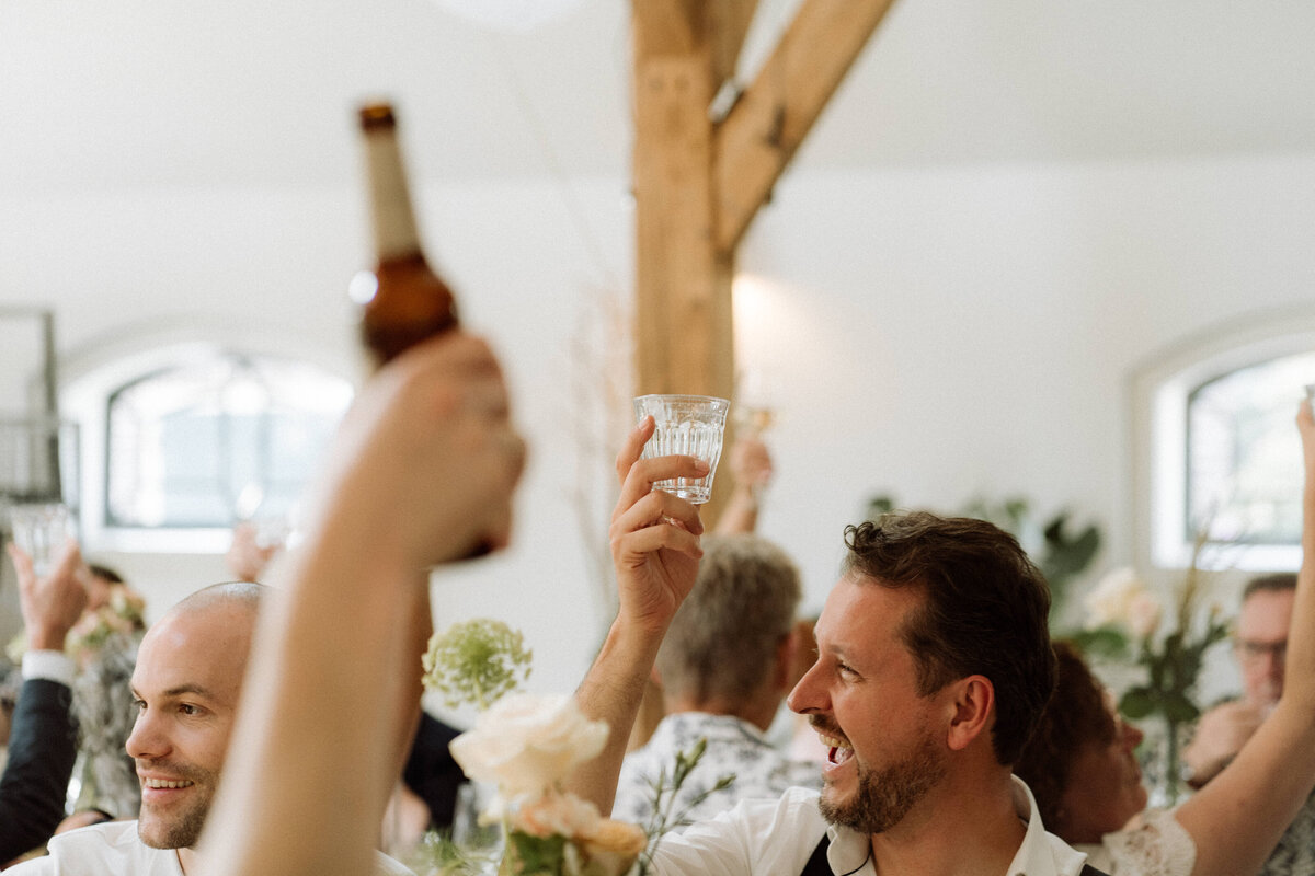 Sfeervolle bruiloft bij Nigtevecht Freeland Farm, met een persoonlijk aangekleed decor en het bruidspaar dat geniet van een lange borrel in een gezellige, intieme sfeer. Proosten. 