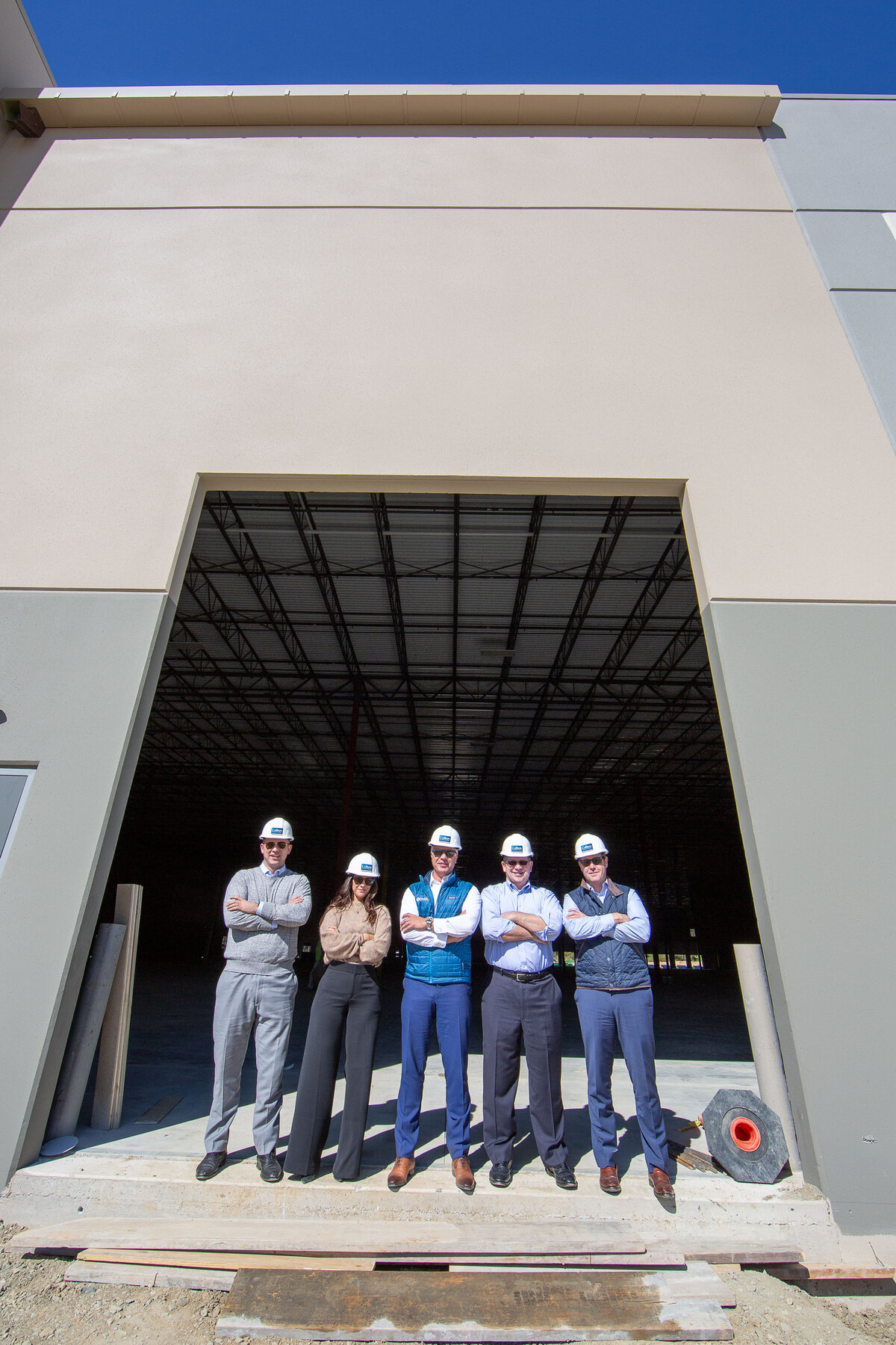 5 people wearing construction hats standing in an industrial doorway