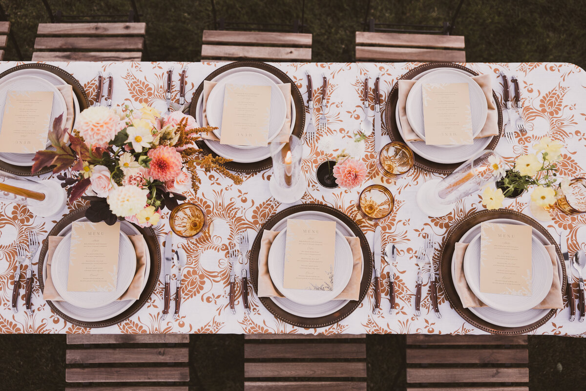 modern outdoor yellow and bronze tablescape with wood accent