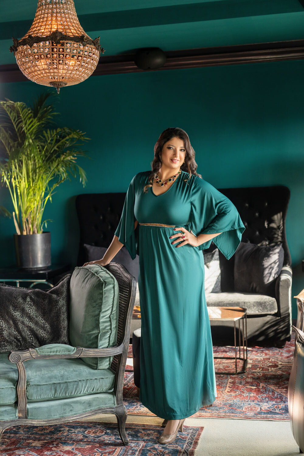 A woman in a green dress is standing in a living room