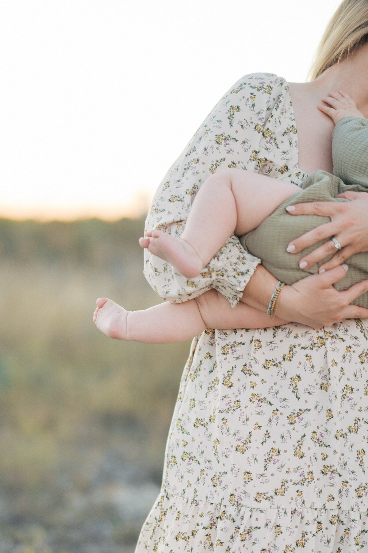 mom holds baby boy and photo is taken of baby toes being held out
