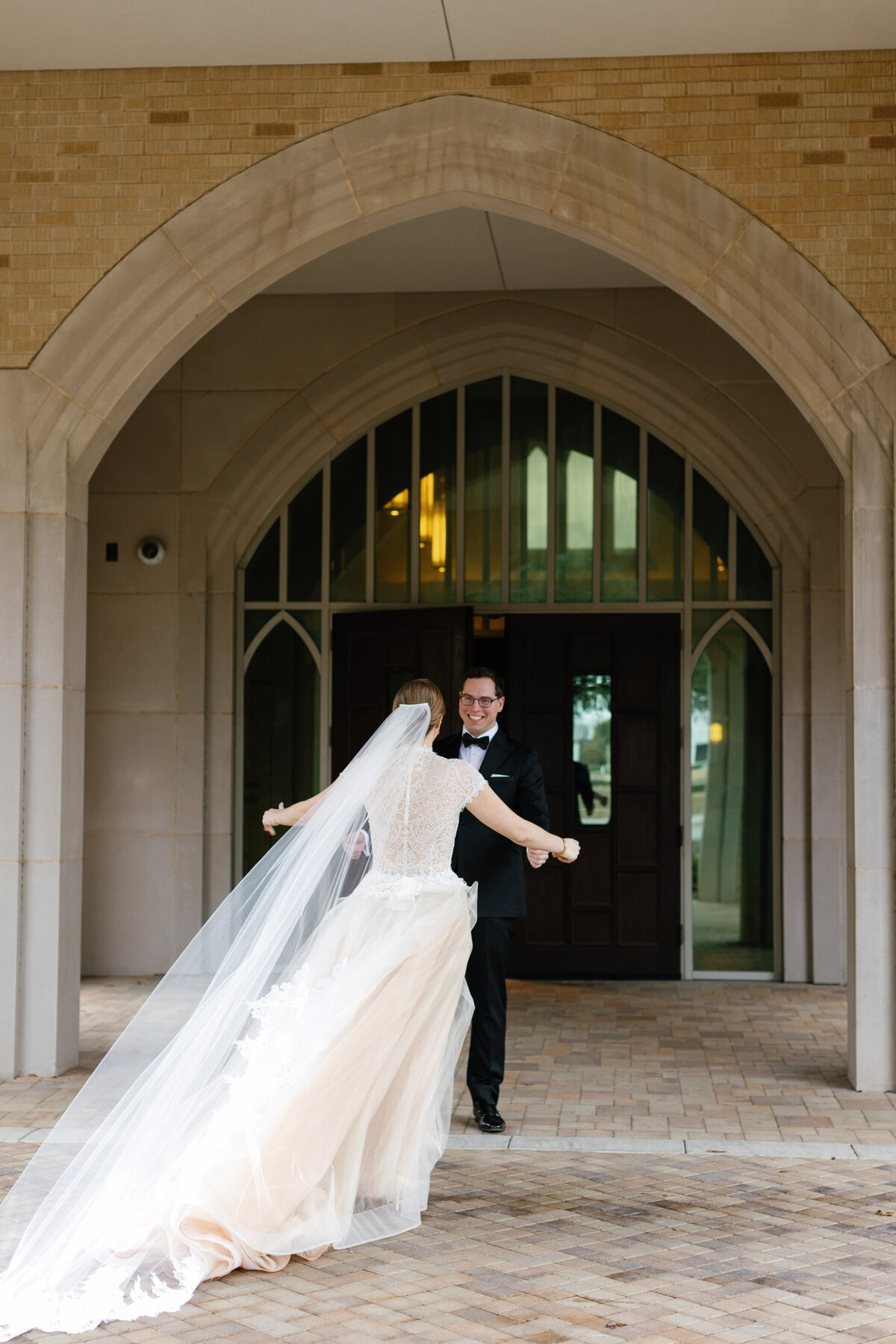 Bride and groom first look in Dallas, with the bride in a lace gown and cathedral veil