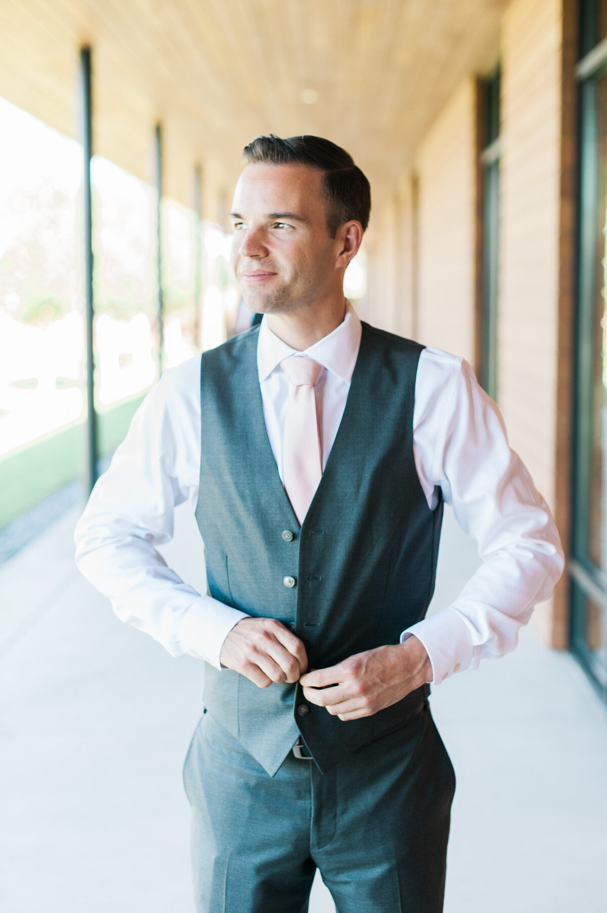 groom buttoning his vest at ponzi winery wedding