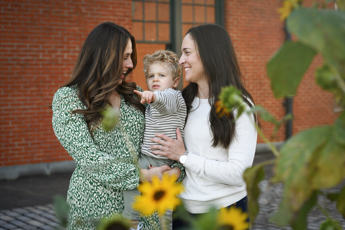 Two moms holding their child in between them