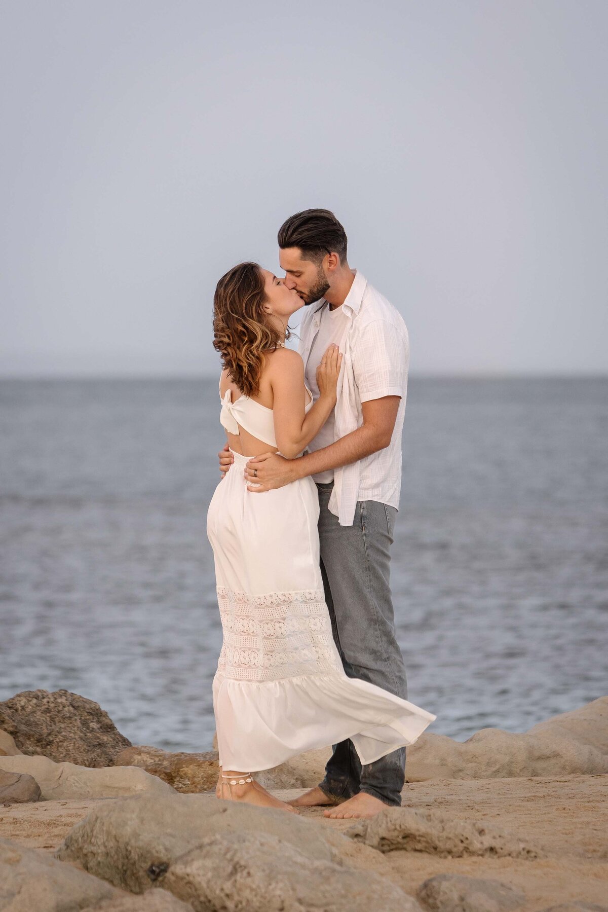 A couple embracing on the rocks on the beach