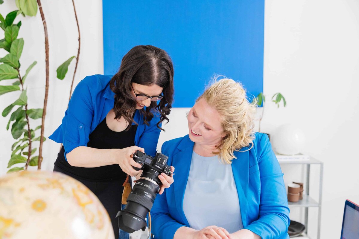 Alicia and Client reviewing back of camera and smiling about successful images