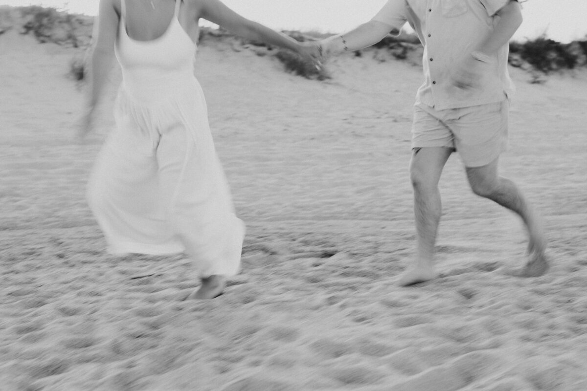 young couple walking through an Indiana field at golden hour 