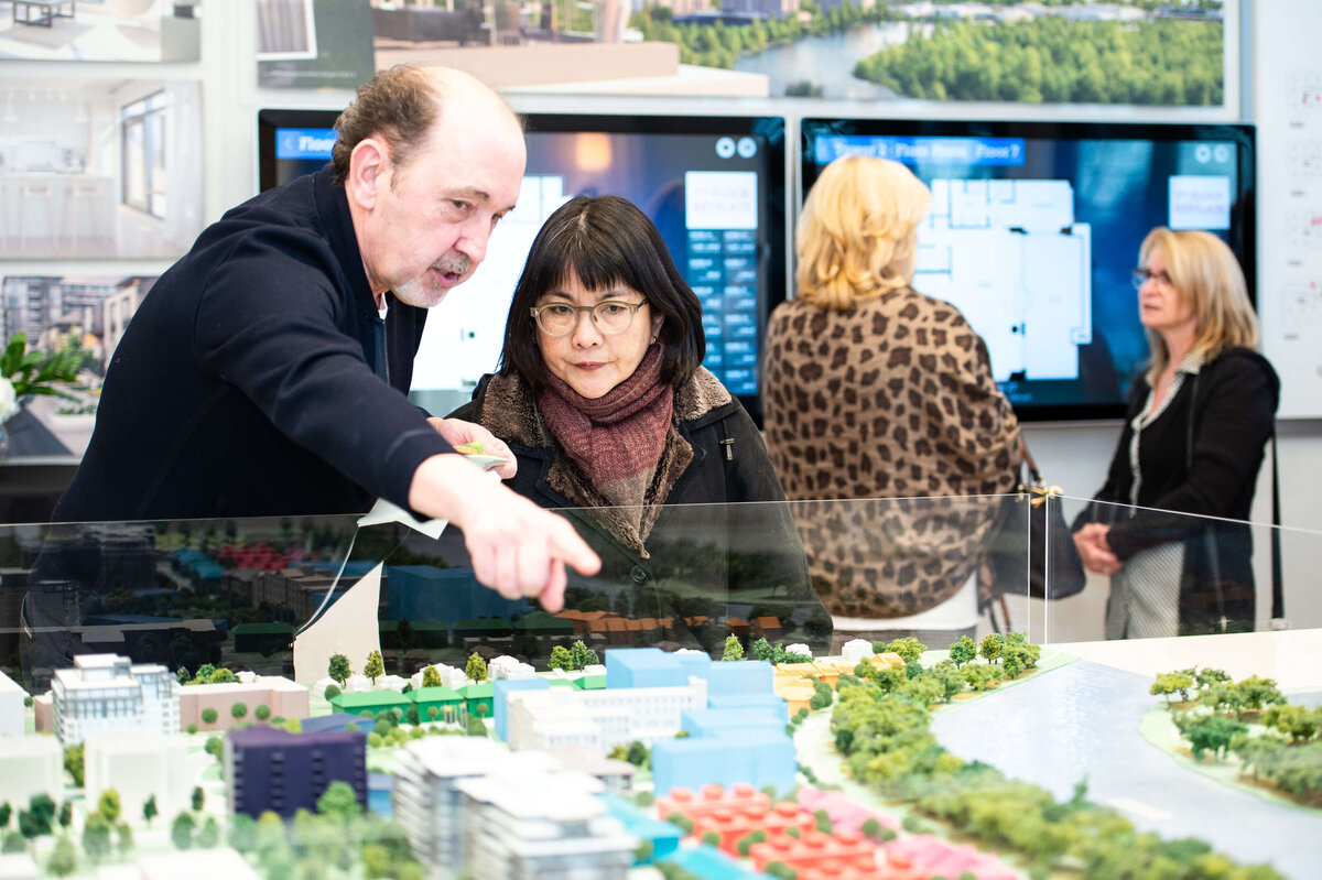 Ottawa event photography showing guests of the eQ groundbreaking event looking at model home plans.  Captured by JEMMAN Photography COMMERCIAL