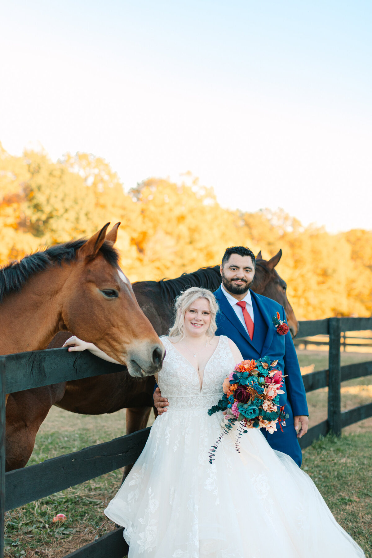 Fall wedding in Virginia with the bride and groom posing with horses