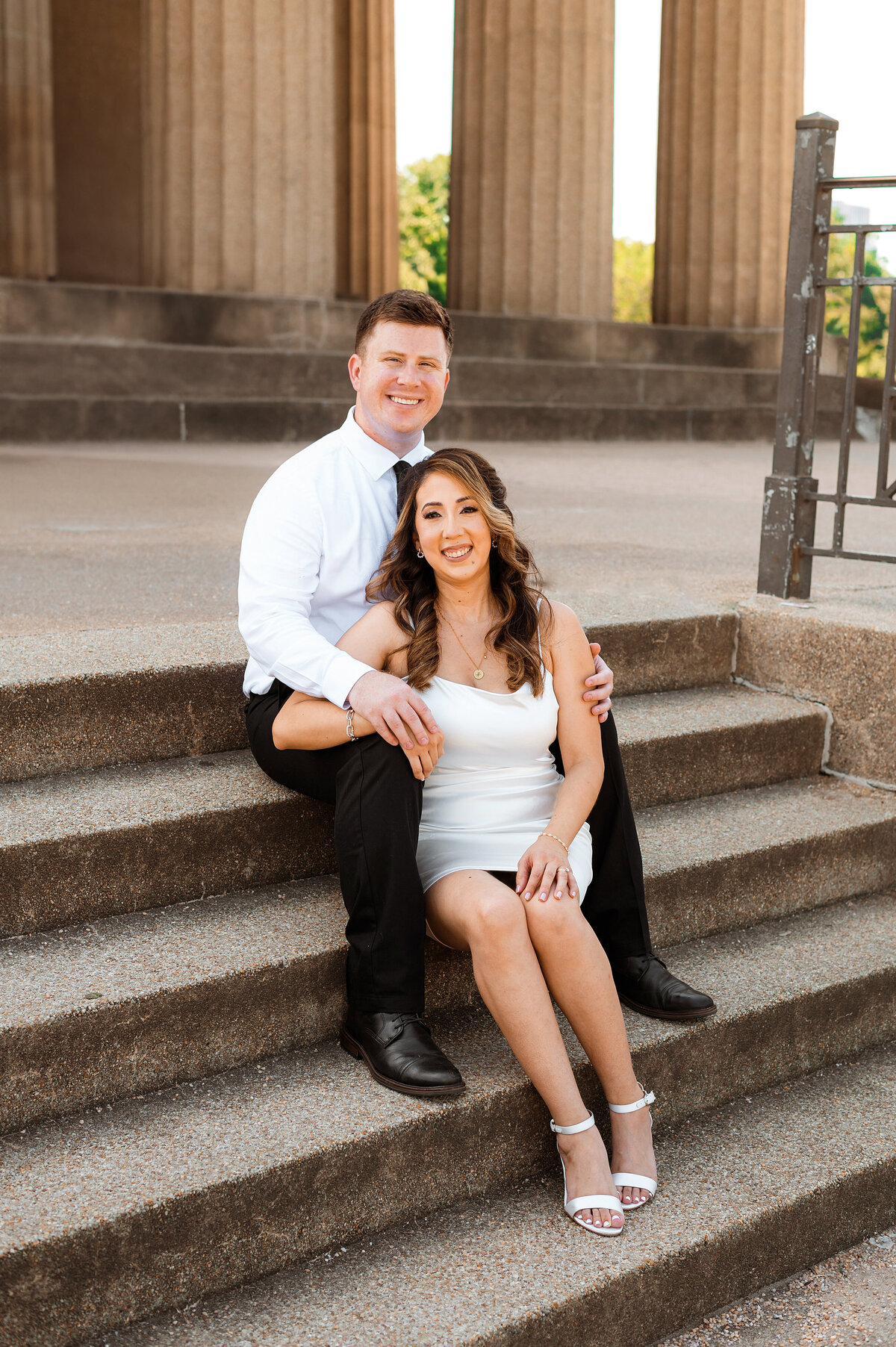 Bride and groom smiling at camera on steps of Nashville parthenon