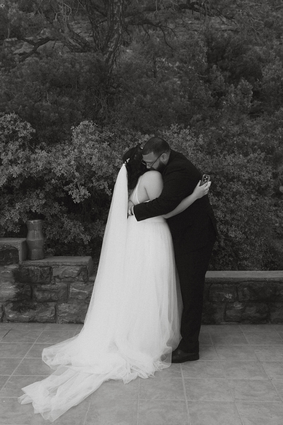 Black and white photo of a newlywed couple hugging 