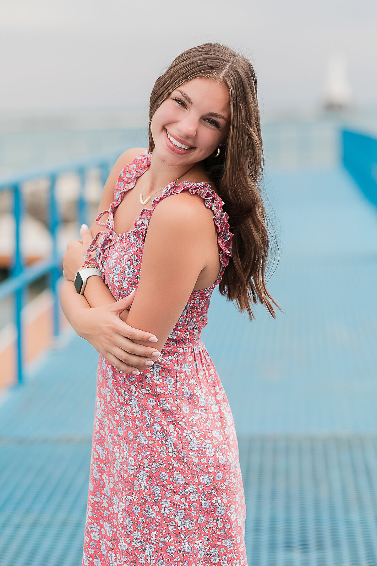 Senior girl standing on a bridge smiling at the camera