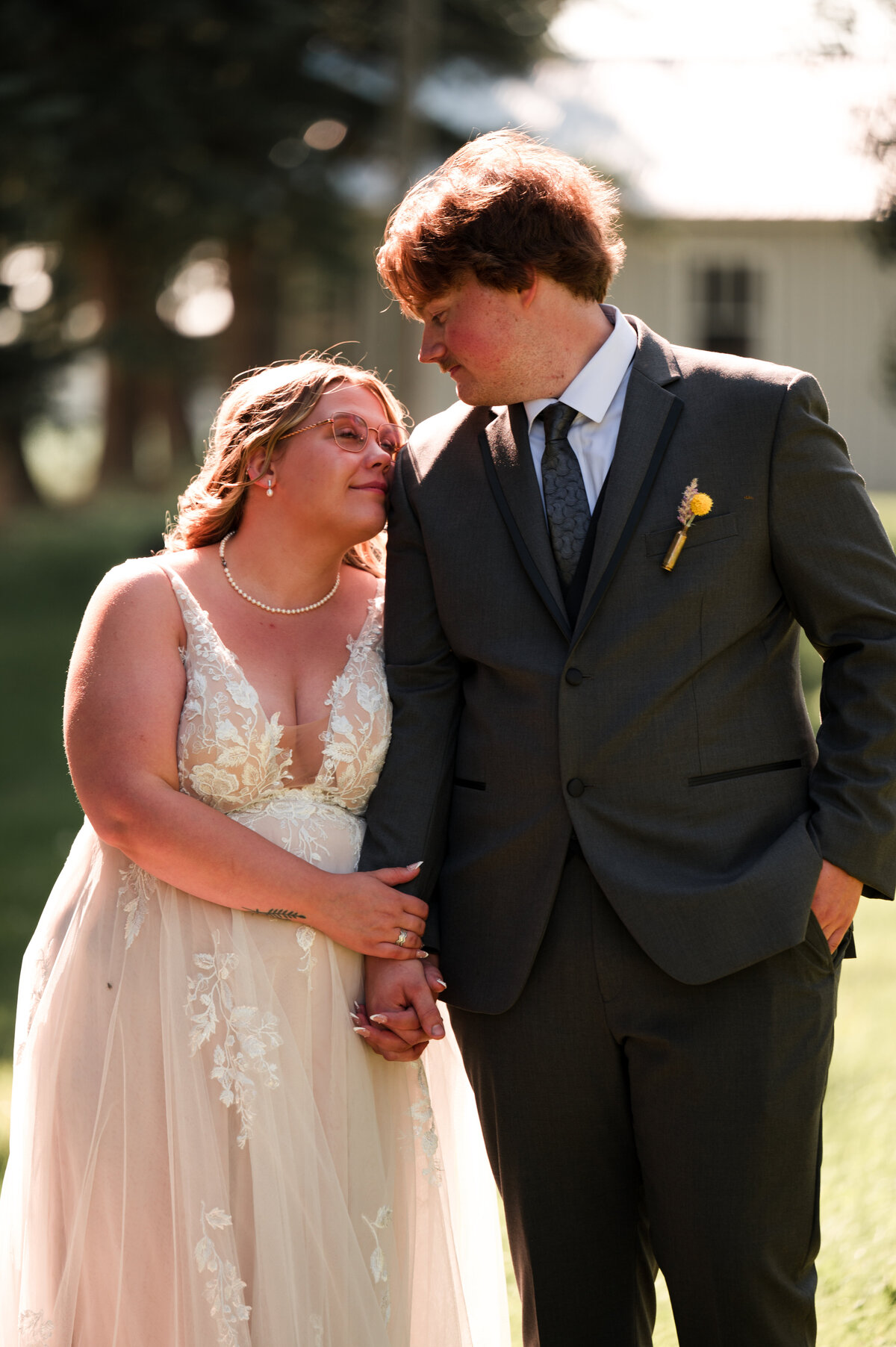 Bride rests her head on grooms shoulder for wedding portrait