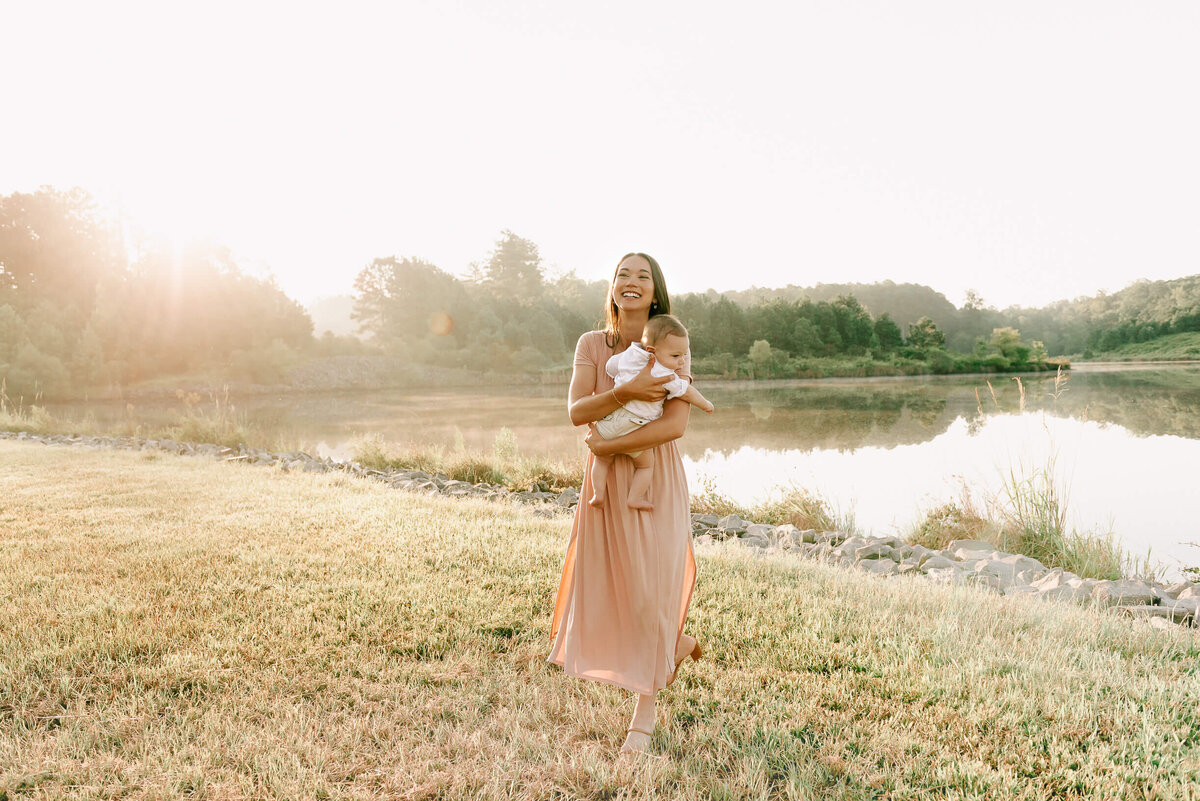 mom holding baby by a lake in raleigh