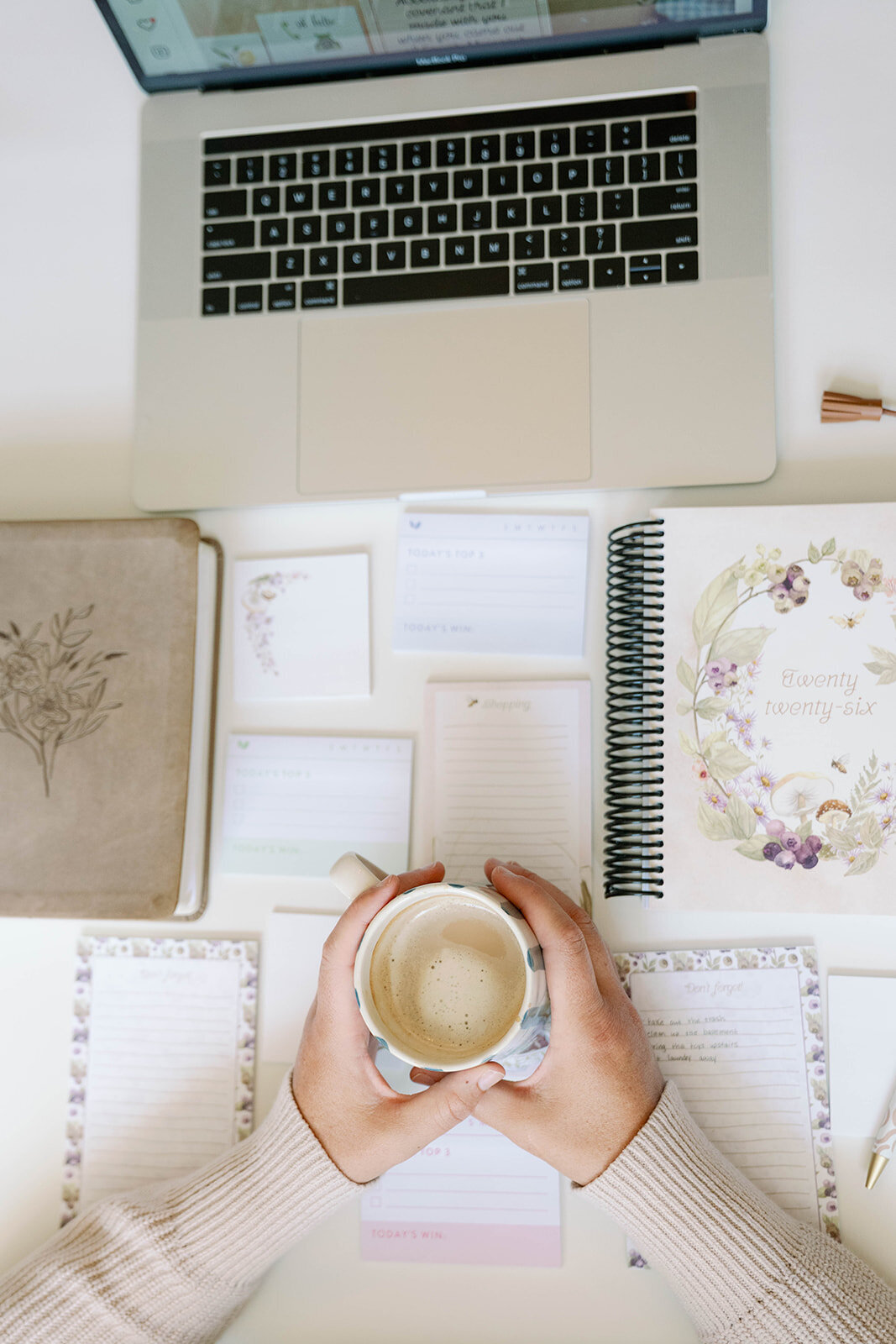 Flatlay of a laptop, coffee, planner, and stationery during a lifestyle branding session for a planner company in Indiana.