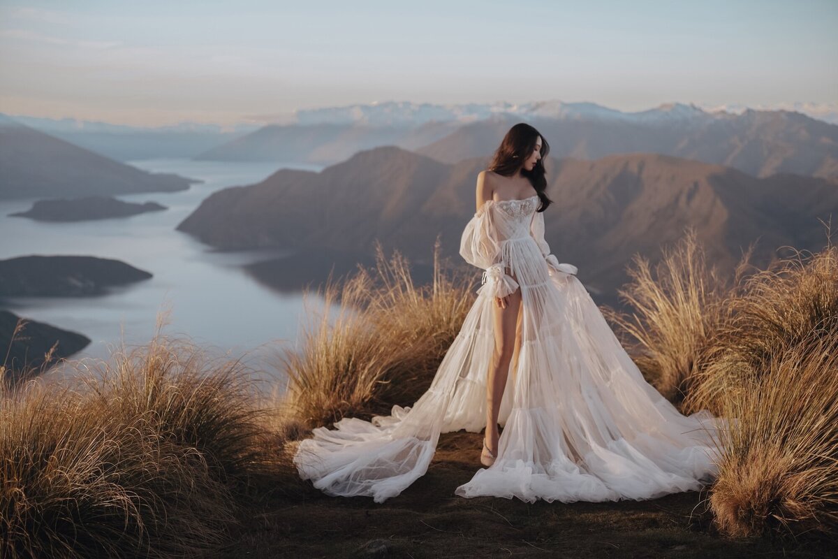 A bride in a couture dress photographed on a mountain overlooking Wanaks