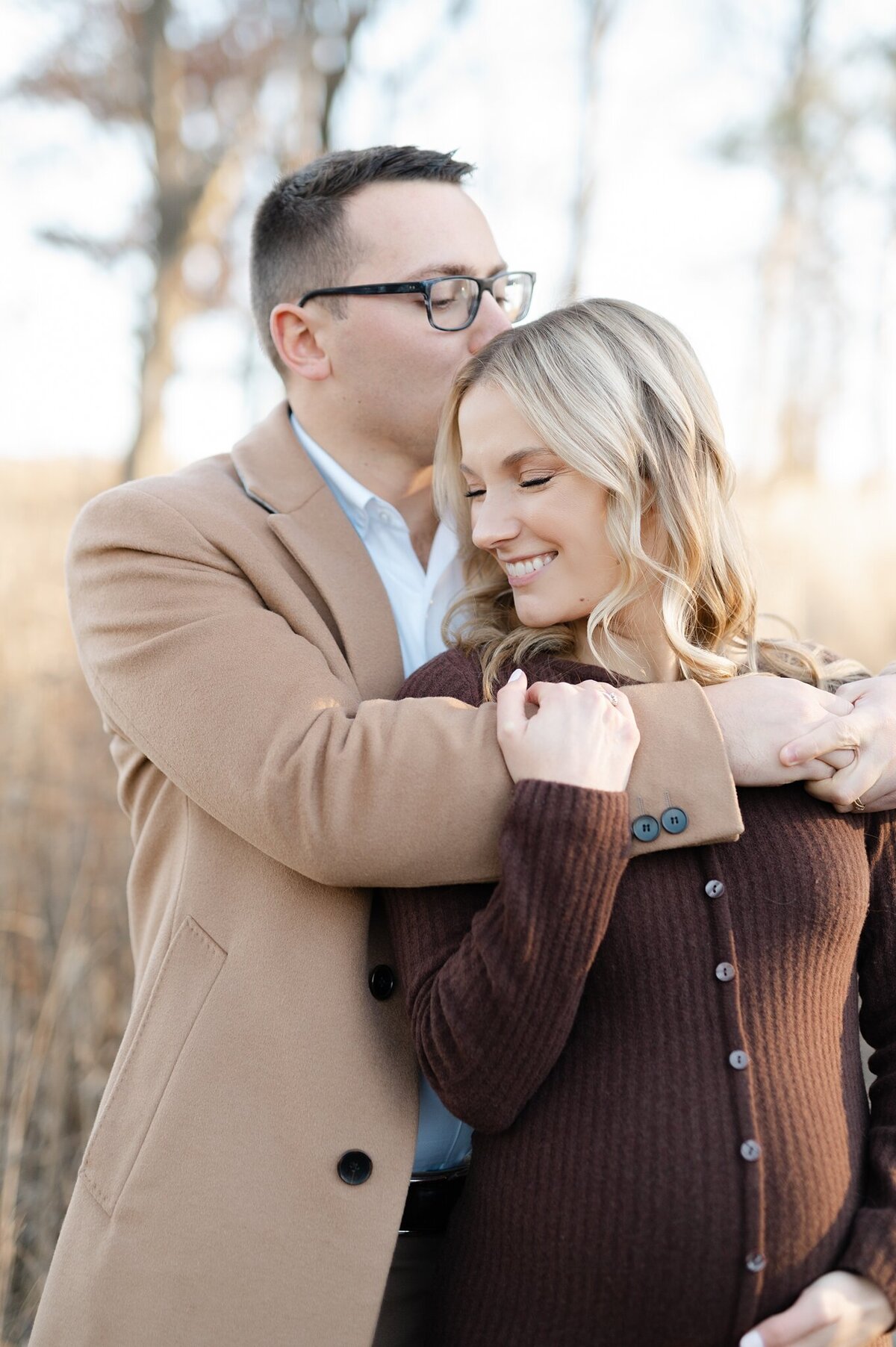 Mother-to-be and her husband embracing during a photoshoot