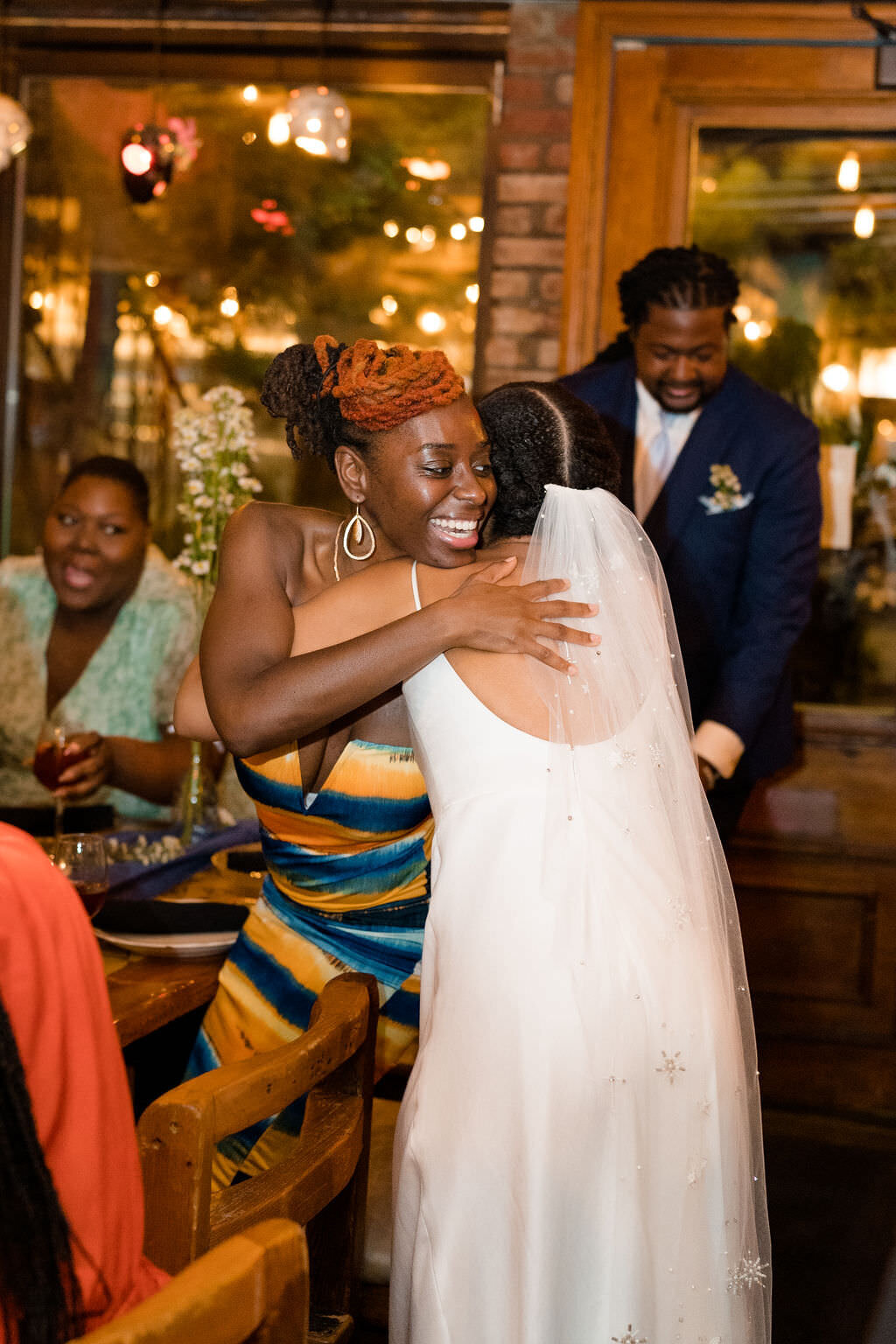bride hugging a guest as other guests talk around them