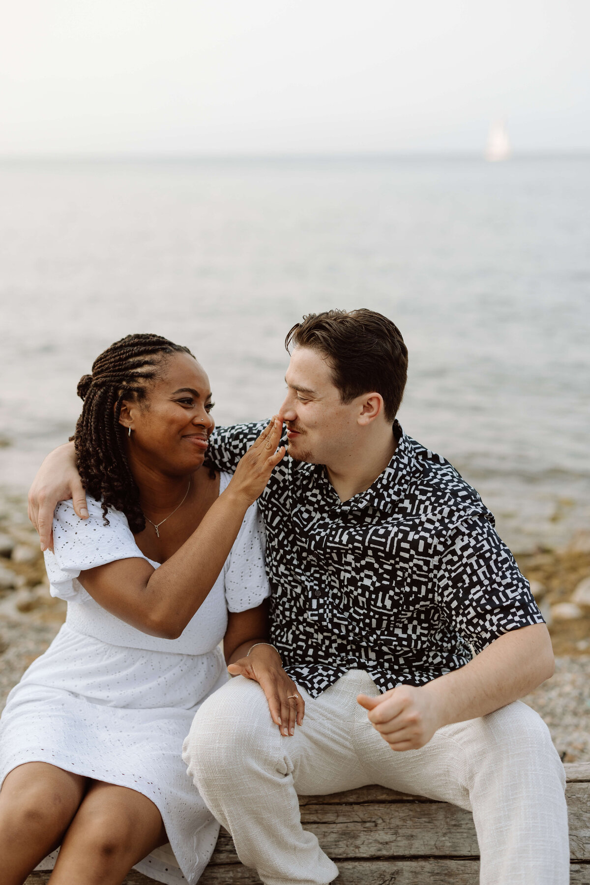 A couple on the beach at their engagement shoot in Niagara On the Lake