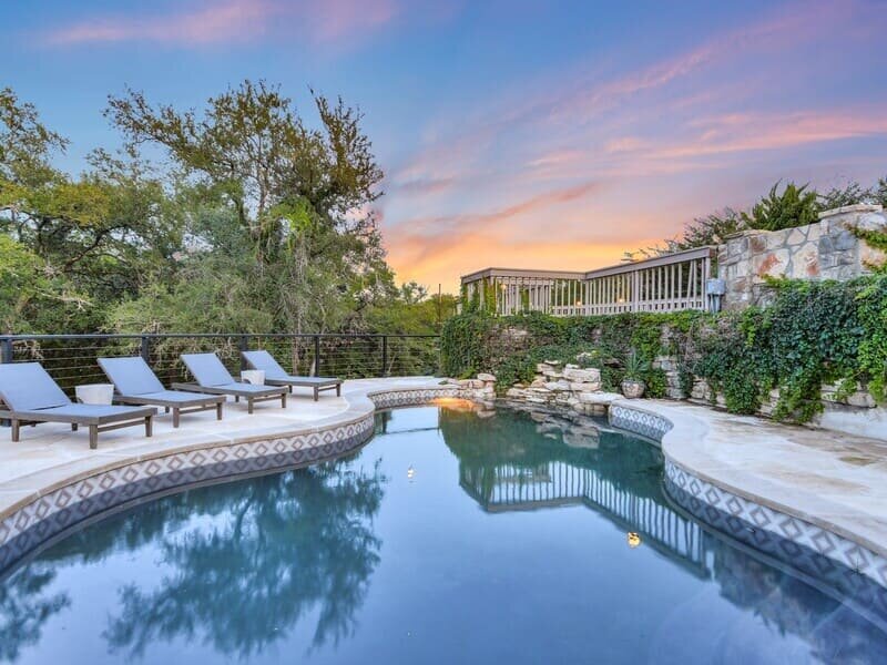 Back pool of luxury rental in Wimberley, Texas with sunbeds