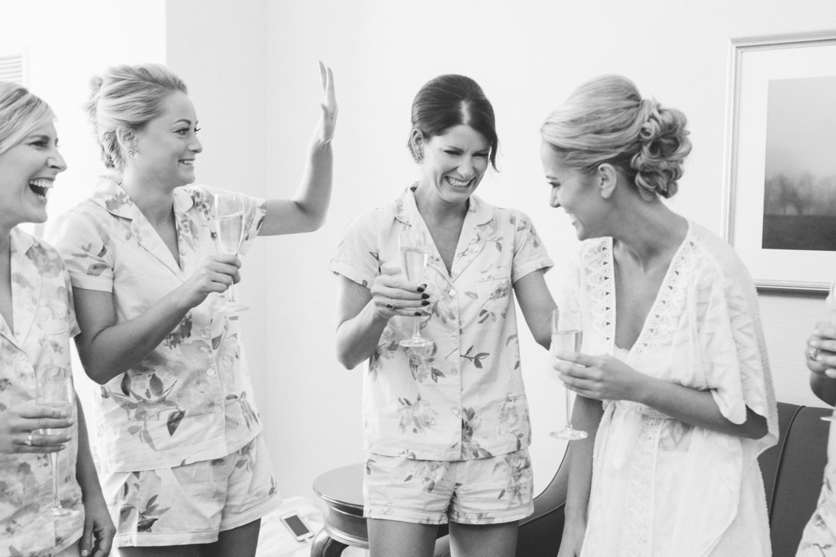 Bridesmaids try not to cry as they toast to the bride.  Real moment documented by photojournalist, Rebecca Cerasani.